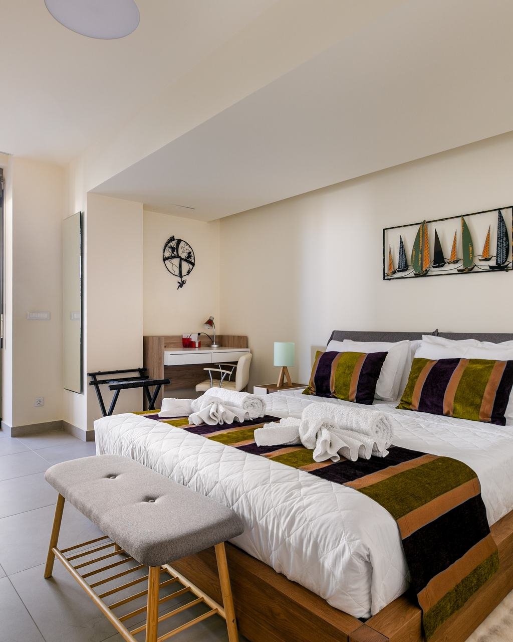 Double bed with a striped throw beside glass doors to the patio